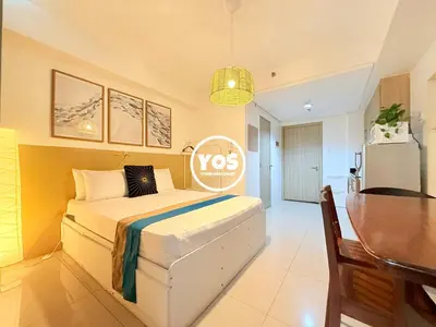 a bedroom with a bed and a table and a desk at Your Own Space Staycation in MOA in Manila