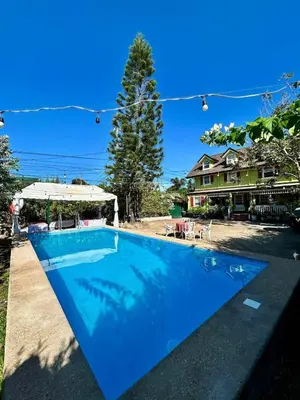 a large blue swimming pool in front of a house at Madie's Place B&B with Private Pool in Santa Rosa near Enchanted Kingdom in Santa Rosa