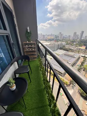 a balcony with two chairs and a table with grass at Coziey Inn in Manila