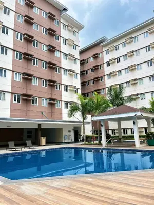 a hotel with a swimming pool in front of a building at Auberge Condotels B at SMDC Hope Residences in Trece Martires
