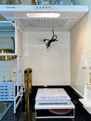 a kitchen with a stove top oven in a refrigerator at Auberge Condotels B at SMDC Hope Residences in Trece Martires