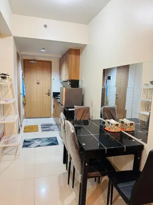 a kitchen with a black table and chairs at MOA Shore 3 One Bedroom Family Suite with Balcony in Manila