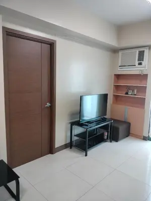 a room with a door and a television on a table at Rooms in Pasay City At Two Palm Tree Villas in Manila