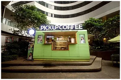 a green building with a coffee shop in front of it at City Best Designer 1BR Makati Fast internet Gym Swim Park 2050 in Manila