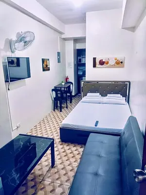 a bedroom with a bed and a couch and a table at Eurica transient Inn Near Terminal 3 in Manila