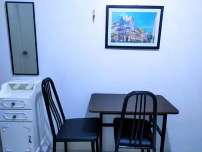 a dining room table with two chairs and a picture on the wall at Eurica transient Inn Near Terminal 3 in Manila