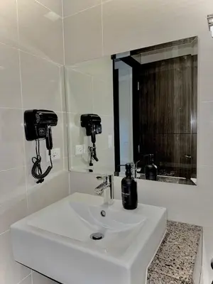 a white bathroom with a sink and a mirror at Condo Venice Luxury Residences Grand canal View in Manila
