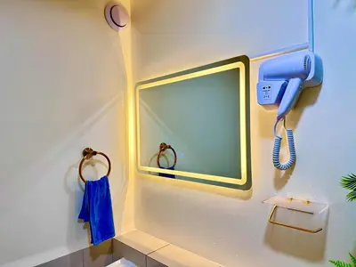 a bathroom with a mirror and a phone on the wall at Cattleya Hearthstone in Manila