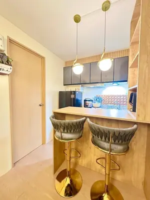 a kitchen with a counter and two bar stools at Cattleya Hearthstone in Manila