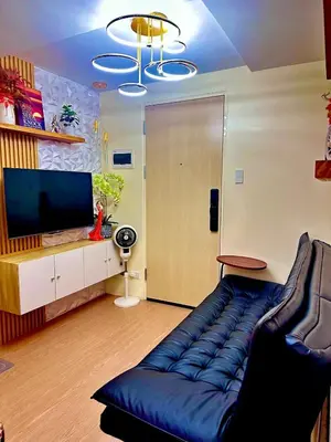 a living room with a couch and a television at Cattleya Hearthstone in Manila