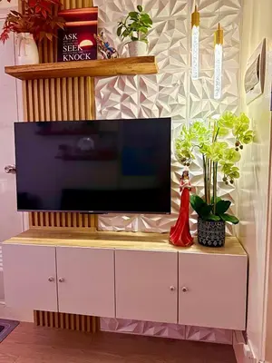 a flat screen tv sitting on top of a white cabinet at Cattleya Hearthstone in Manila