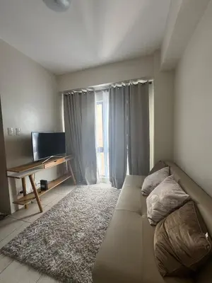 a living room with a couch and a television at East Bay Residences Condo Unit in Muntinlupa in Manila