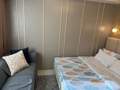 a small bedroom with a bed and a couch at Shore 3 Residence Aesthetic 1 BR in Manila