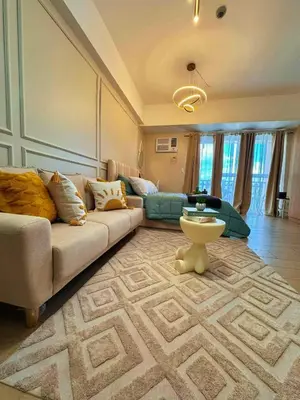 a living room with a couch and a table at Cozy Unit near Venice Grand Canal Mall McKinley Hill Taguig in Manila