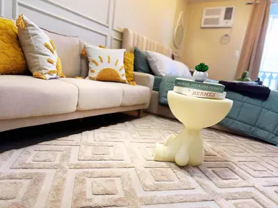 a living room with a couch and a table with books on it at Cozy Unit near Venice Grand Canal Mall McKinley Hill Taguig in Manila