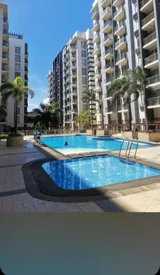 a large swimming pool in front of some buildings at One Tree villas - Hyuna Place, Across NAIA T3 in Manila
