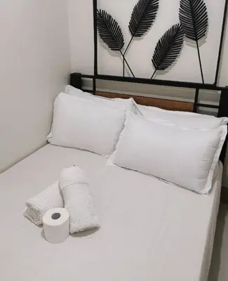 a white bed with two towels and two pillows at Mao condotel shore 3 residence in Manila