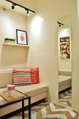 a living room with a couch and a mirror at Modern Zen 1-bedroom with balcony in Manila