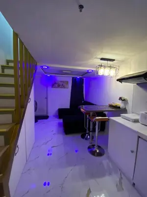 a purple room with a table and a couch at Condo apartment in Manila