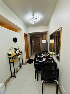 a dining room with a table and chairs in a room at Meteoria Staycation in Manila