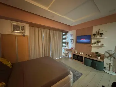 a bedroom with a bed and a tv in a room at Elegant Suite with Balcony l Free wifi and netflix I Across NAIA T3 Airport in Manila