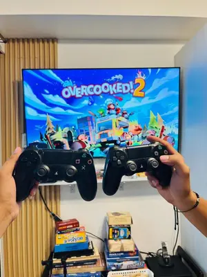 a person holding a video game controller in front of a tv at Azure Beach View with Balcony PS4 Billiards in Manila