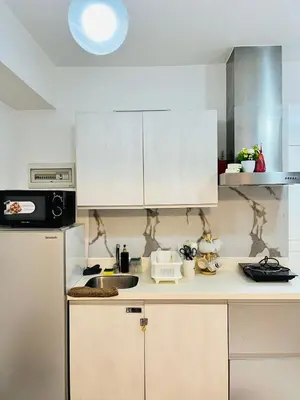 a kitchen with white cabinets and a sink at Azure Beach View with Balcony PS4 Billiards in Manila