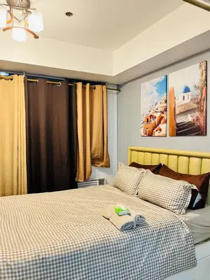 a bedroom with a bed with a checkered blanket at Azure Beach View with Balcony PS4 Billiards in Manila