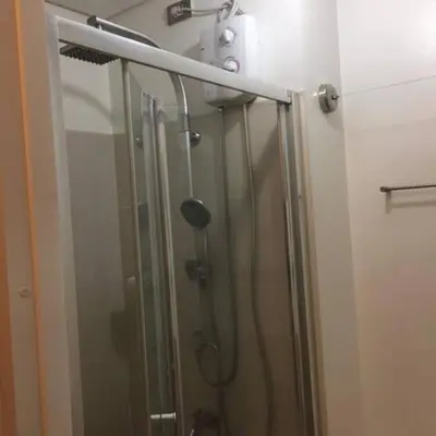 a shower with a glass door in a bathroom at Bernie and Adel's Property Rental in Manila