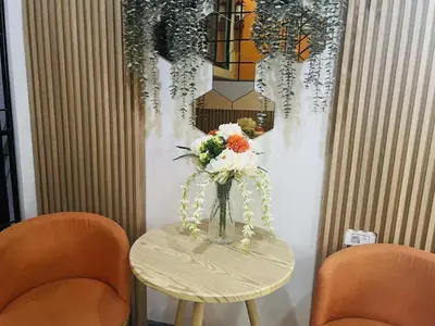 a vase of flowers on a table with two chairs at OYO 1158 Kegama Residences 2 in Cavite