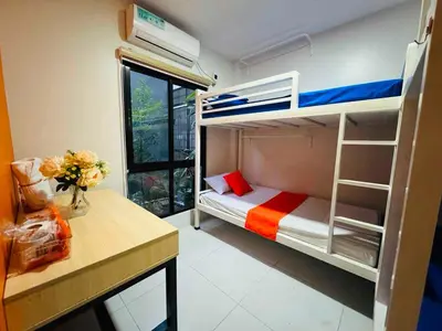 a bedroom with a bunk bed and a desk with flowers at OYO 1157 Kegama Residences 1 in Cavite