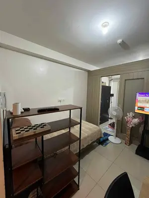 a bedroom with a bed and a television in it at Cozy 2 Beds Near Mall of Asia in Manila