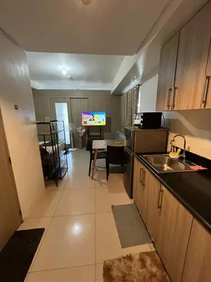 a kitchen with a sink and a table in a room at Cozy 2 Beds Near Mall of Asia in Manila