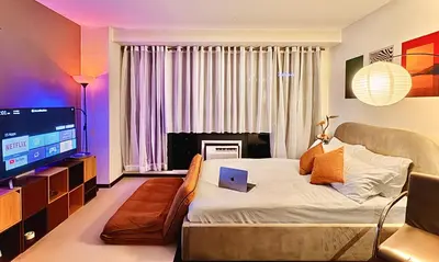 a bedroom with a bed with a laptop on it at The Gramercy Residences in Manila
