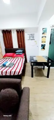 a room with a bed and a table in it at Alabang homely in Manila