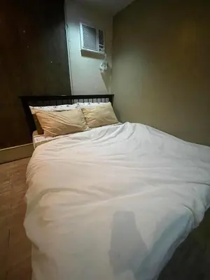 a large white bed sitting in a bedroom at Studio Condominium by Koteniko in Manila
