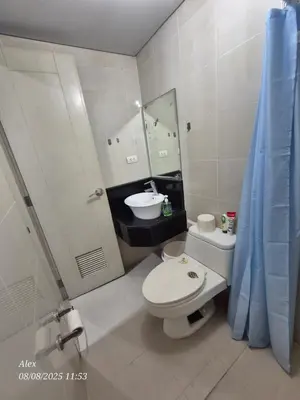 a bathroom with a toilet and a sink and a mirror at 1BR Condo at NAIA and Newport Casino Area in Manila