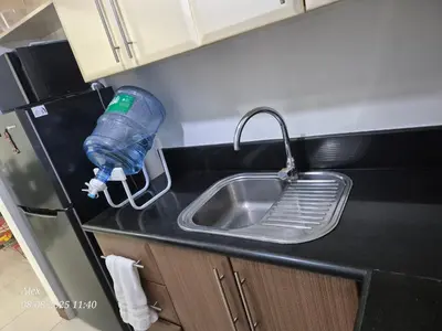 a kitchen sink with a water bottle attached to a faucet at 1BR Condo at NAIA and Newport Casino Area in Manila