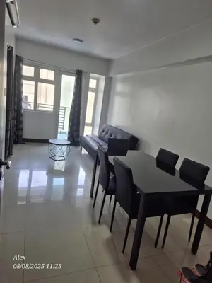 a living room with a table and chairs and a couch at 1BR Condo at NAIA and Newport Casino Area in Manila