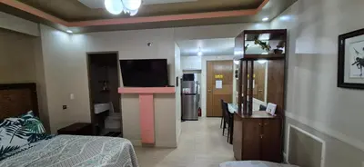 a room with a bedroom with a bed and a television at Affordable Rooms by Rqui Near Airports in Manila