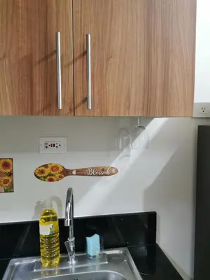 a kitchen sink with a wooden spoon on the wall at Mall of Asia condotel shore 3 in Manila