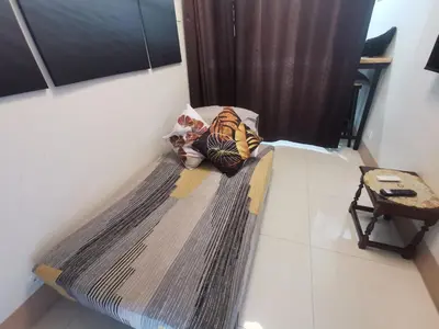 a bed in a room with a blanket on it at Mall of Asia condotel shore 3 in Manila
