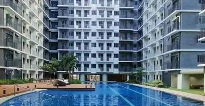 a large apartment building with a large swimming pool at Mall of Asia condotel shore 3 in Manila