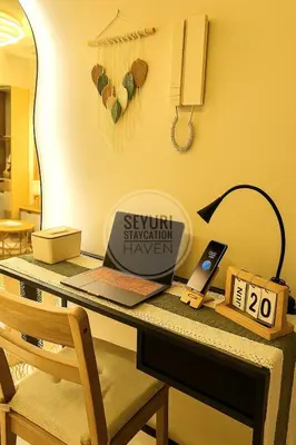 a desk with a laptop and a phone on it at Seyuri Staycation Haven in Manila