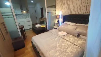 a bedroom with a large bed with a large mirror at Aveline Suites Riverline in Manila