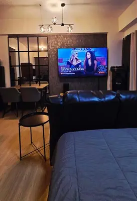 a living room with a couch and a flat screen tv at SW Staycation Liam Suite SMDC Hope Residences Beside SM City in Trece Martires