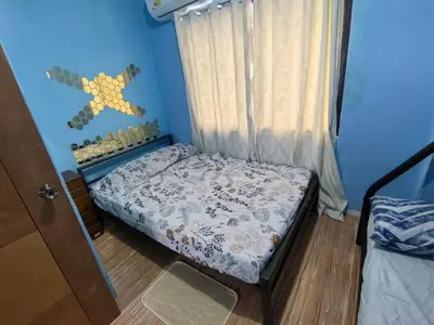 a small bed in a room with a curtain at Harong ni Lynda in Ibaba