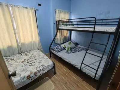a bedroom with two bunk beds and a bed at Harong ni Lynda in Ibaba