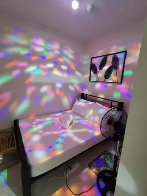 a bedroom with a bed with a multicolored bedspread at Mall of Asia shore 3 tower 2 residence in Manila