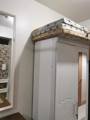 a white cabinet in a room with a mirror at Mall of Asia shore 3 tower 2 residence in Manila